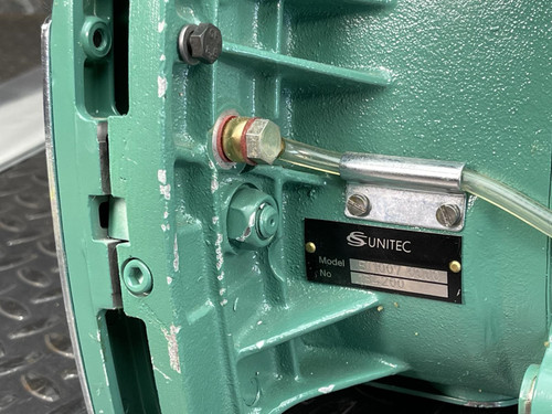 Detailed view of the CS Unitec Pneumatic Chainsaw's inner mechanism from Obtainium Science and Surplus, focusing on the label and attached components.