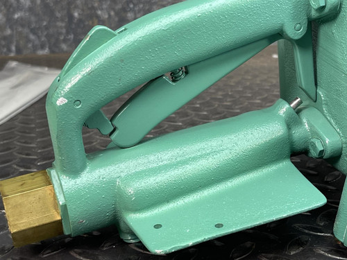 Close-up of the CS Unitec Pneumatic Chainsaw's handle and attachment point, showing a brass connector from Obtainium Science and Surplus.