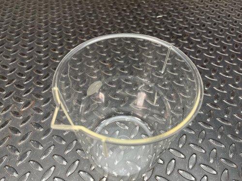 Top view of a Nalgene beaker from Obtainium Science and Surplus on a textured surface.