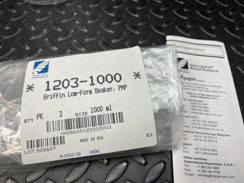 Packaging labeled 'Nalgene Beaker' from Obtainium Science and Surplus next to an instruction manual on a textured surface.