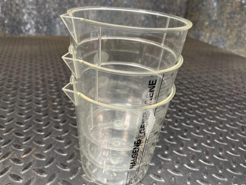 Three Nalgene beakers from Obtainium Science and Surplus stacked together on a textured surface.