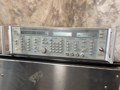 Straight-on view of the Wiltron 6769B Synthesized Sweep Generator from Obtainium Science and Surplus, mounted on a shiny metal surface.