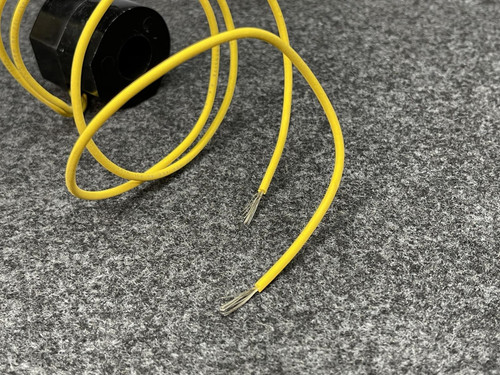 Focused shot of the yellow wires from the ASCO Replacement Coil 222345-009-D, highlighting their metal ends on the gray textured surface.
