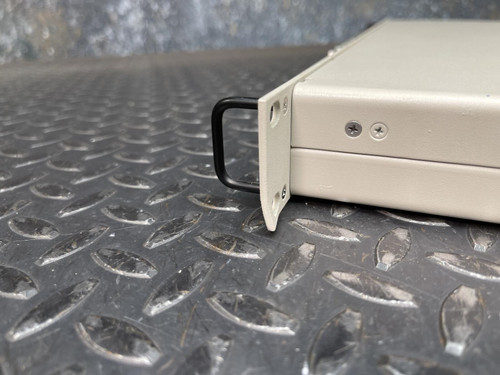 A close-up of the mounting bracket and side detail of the National Instruments BNC-2090 terminal block, placed on a textured metal surface. This item is from Obtainium Science & Industry Surplus.