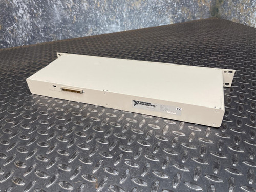 A National Instruments BNC-2090 terminal block with a CE label and product details on a textured metal surface. This terminal block is available from Obtainium Science & Industry Surplus.