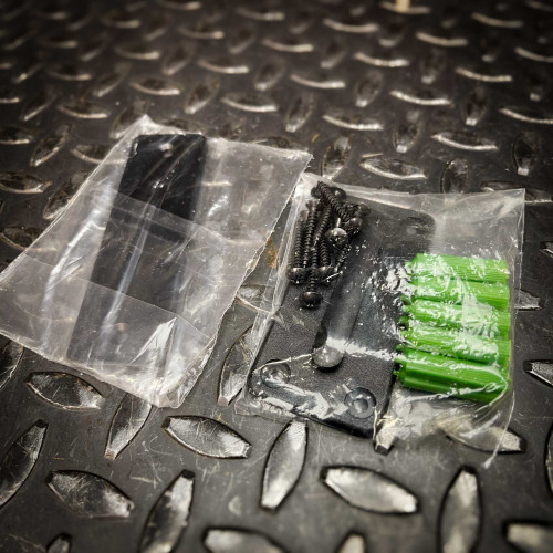 Accessories for the Crowd Control Warehouse Magnetic Retractable Belt Barrier from Obtainium Science and Surplus, including screws, anchors, and wall mount brackets, neatly packed in plastic bags on a textured surface.