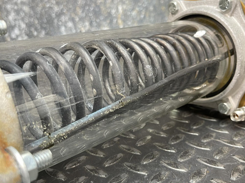 Close-up of the custom vacuum/pressure chamber from Obtainium Science and Surplus, focusing on the internal coil within the glass body, emphasizing the chamber's function for heat exchange.