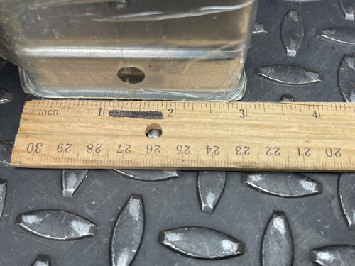 Close-up of the bottom section of a Nylatube Energy Chain Wireway, with a wooden ruler placed below it for scale, showing measurements in centimeters. The wireway is displayed on a textured metal surface, emphasizing its precise dimensions and robust construction.