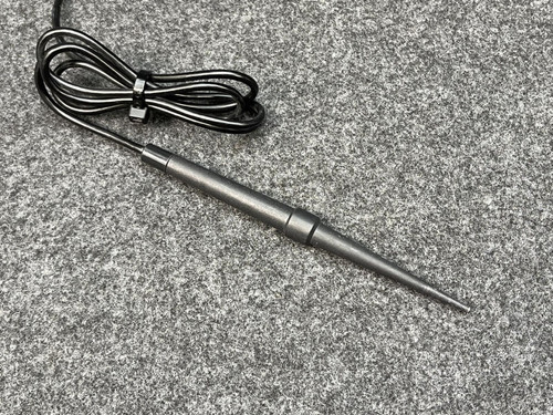 Close-up of the Fluke Temperature Probe from Obtainium Scientific Surplus, focusing on the metal probe tip laying on a gray textured surface.