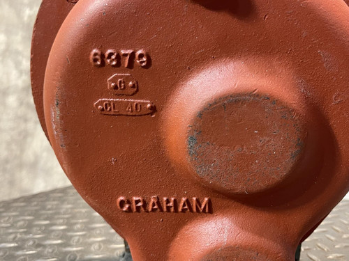 Close-up of the rear side of the Graham heat exchanger from Obtainium Science and Surplus, highlighting the embossed “Graham” marking and model number on the red painted surface, emphasizing its sturdy industrial design.