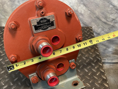 Front view of the Graham heat exchanger from Obtainium Science and Surplus with a yellow measuring tape across the unit for scale, showing the two primary ports and surrounding bolts on the red metal end plate.