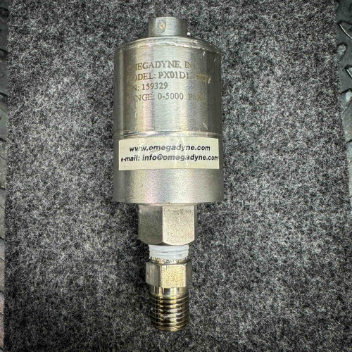 Image of an Omega pressure transducer model PX01D1, showing its details including the range of 0-5000 PSI and the contact information "www.omegadyne.com" and "info@omegadyne.com." The device is used for measuring pressure and is placed on a textured surface.
