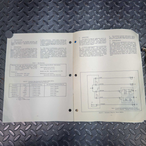 Opened operating manual of the Hewlett Packard 16021A Test Fixture showing detailed instructions and diagrams.
