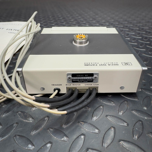 Rear view of the Hewlett Packard 16021A Test Fixture displaying the connection ports and several connected cables.