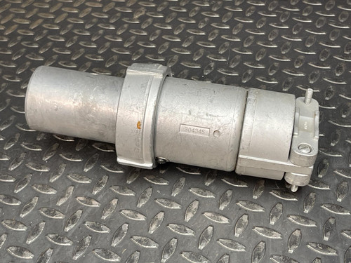 Side view of an Appleton 100A plug from Obtainium Science and Surplus, displaying its metallic cylindrical body with a clasp mechanism, placed on a metal surface.