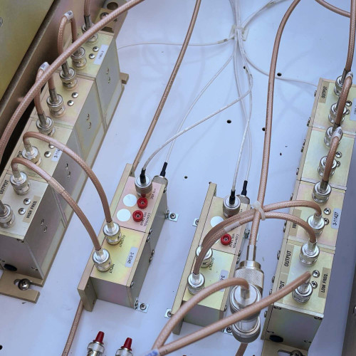 Close-up of internal components of a TX RX Systems UHF radio frequency booster from Obtainium Science and Surplus, highlighting the wiring connections.
