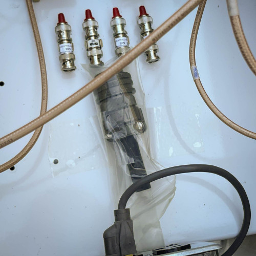 Close-up of connectors and cables inside the TX RX Systems UHF radio frequency booster from Obtainium Science and Surplus, showing four red-tipped connectors.