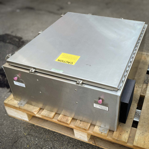 Side view of the TX RX Systems UHF radio frequency booster from Obtainium Science and Surplus, with a closed metallic cover, placed on a wooden pallet.