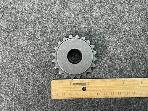 Top-down view of the Martin D35B20H sprocket positioned next to a wooden ruler for size reference, highlighting the 20 teeth and central hole.