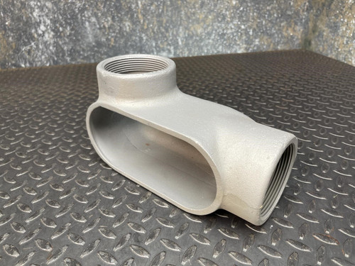 A 3-inch Appleton LL conduit body from Obtainium Science and Surplus, viewed from an angle, showing its gray metallic surface and oval opening.