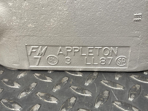 A close-up of a 3-inch Appleton LL conduit body from Obtainium Science and Surplus, highlighting the embossed text 'FM7 APPLETON 3 LL87'.