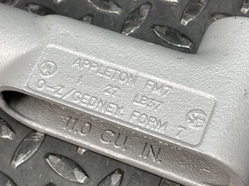Close-up of the label on a 1" Appleton LB Conduit Body from Obtainium Science and Surplus, displaying the text "APPLETON FM7, 27, O-Z/GEDNEY FORM 7, 11.0 CU. IN.".