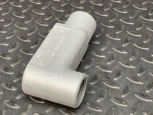 Another angled side view of a 1" Appleton LB Conduit Body from Obtainium Science and Surplus on a diamond plate surface.