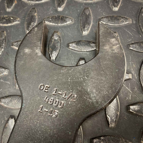 Close-up of the head attachment on the Sturtevant Richmont Exacta 2 digital torque wrench, featuring engraved specifications "OE 1-1/2 480U 1-15". The attachment is designed for precise torque applications and fits securely onto the handle. The tool is placed on a textured metal surface, available from Obtainium Science & Industry Surplus.