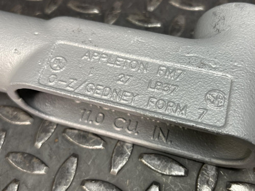 Close-up of the label on a 1" Appleton LB37 Conduit Body from Obtainium Science and Surplus, displaying the text "APPLETON FM7, 27, O-Z/GEDNEY FORM 7, 11.0 CU. IN.".