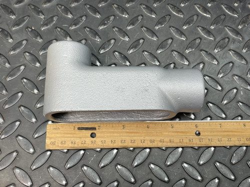 The detachable cover of a 1" Appleton LB37 Conduit Body from Obtainium Science and Surplus, shown separately on a diamond plate surface.