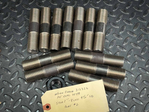A set of twelve B7 stud bolts, each measuring 4.5 inches in length and 1 inch in diameter with 8 UNC threading. The bolts are arranged on a textured surface with a labeled tag included. Available from Obtainium Science & Industry Surplus.