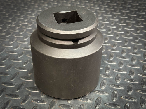 A cylindrical metal socket with a square opening at the top, displayed on a textured metal surface. The product is from Obtainium Science & Industry Surplus.
