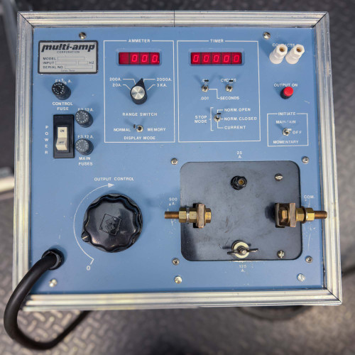 Close-up view of the control panel of the Megger Multi-Amp CB-832 Circuit Breaker Tester, showing various knobs, switches, and digital displays on a blue background.