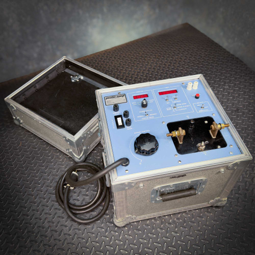 Megger Multi-Amp CB-832 Circuit Breaker Tester available from Obtainium Science and Surplus. The tester is displayed with its protective case open, revealing the controls and components on a blue panel.