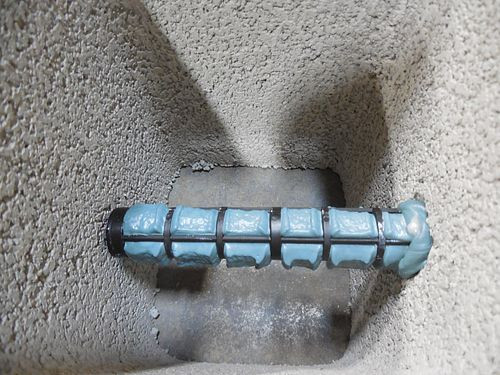 Specially sized holes in Opti-Mesh screens allow for adhesive to seep out at the appropriate location at the hollow portion of the CMU to create a better bond to the face shell.
