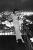 1970\'s night time fashion shoot on balcony with striped gown and feathered boa wrap
