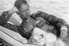 1970's fashion shoot relaxing at the pool with cute white fluffy puppy