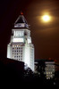 Fine art photograph by Robert Landau of the illuminated 1928 Los Angeles City Hall Art Deco tower against a hazed full moon.