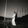 Kowloon by Gleb Derujinsky | Vintage Fashion Photo. Model on a boat dock wearing white at dusk