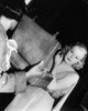 Candid photo of Jean Harlow checking her make-up backstage.