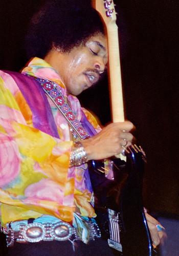 Jimi Hendrix #3 Photo by Jeffrey Mayer wailing on his guitar in lively colored purple yellow shirt