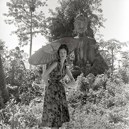 Fashion shot of a model in front of a Buddha by Gleb Derujinsky