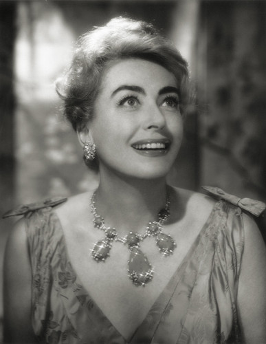 Joan Crawford smiling, adorned with pretty necklace. Shot by John Engstead, 1961.