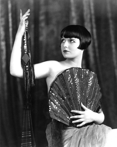 Classic Louise Brooks photo as she uses a fan to tease the camera.