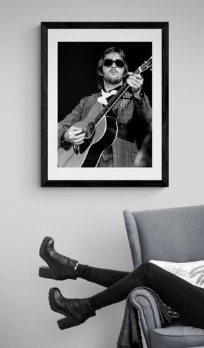 Eric Clapton by Richard E. Aaron | Classic Rock Photo | Limited Edition Print | Eric Clapton 1974, at Nassau Coliseum. | Clapton looking cool with dark shades playing his guitar | Framed in black and displayed by reading chair.