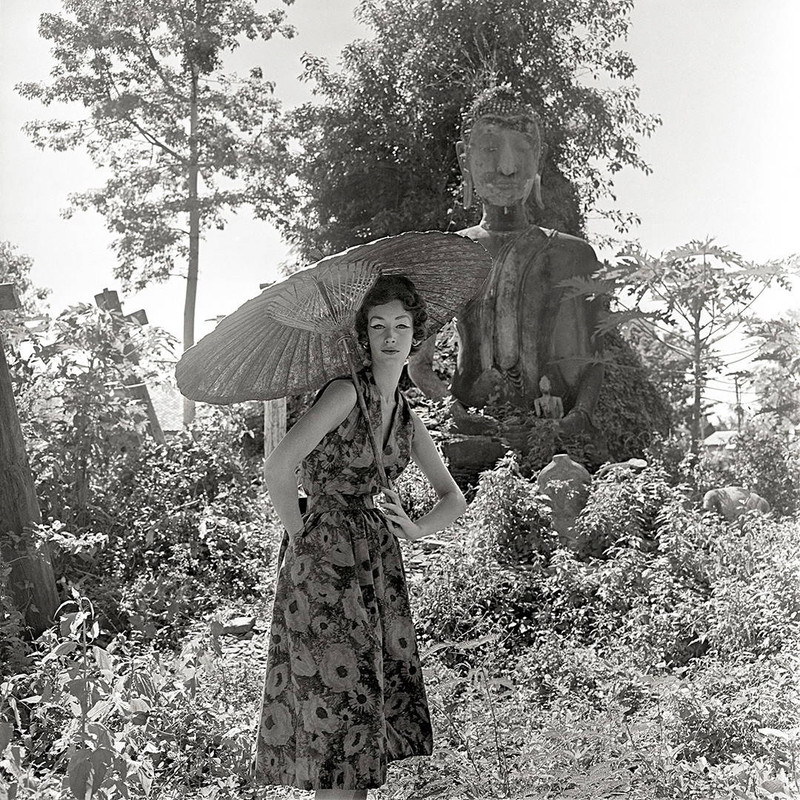 Fashion shot of a model in front of a Buddha by Gleb Derujinsky