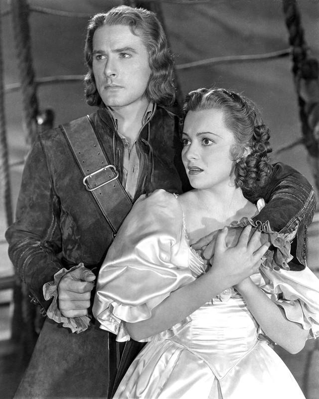 Striking shot of Errol Flynn and Olivia de Havilland on the set of Captain Blood.