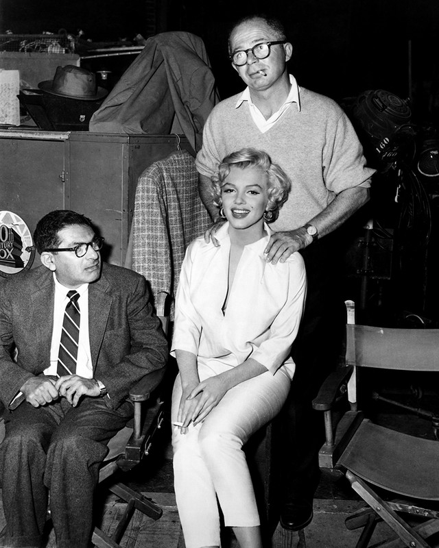 Production Still of Marilyn Monroe backstage, getting a back rub.