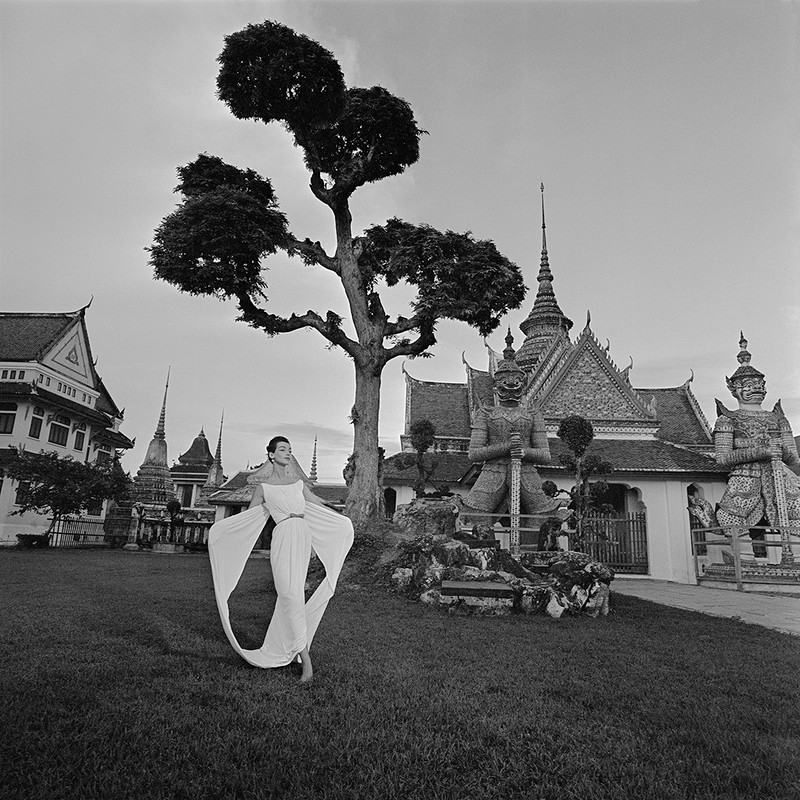 Temple of Dawn Photo by Gleb Derujinsky. Model in a white gown shot at the Grand Palace in Thailand.