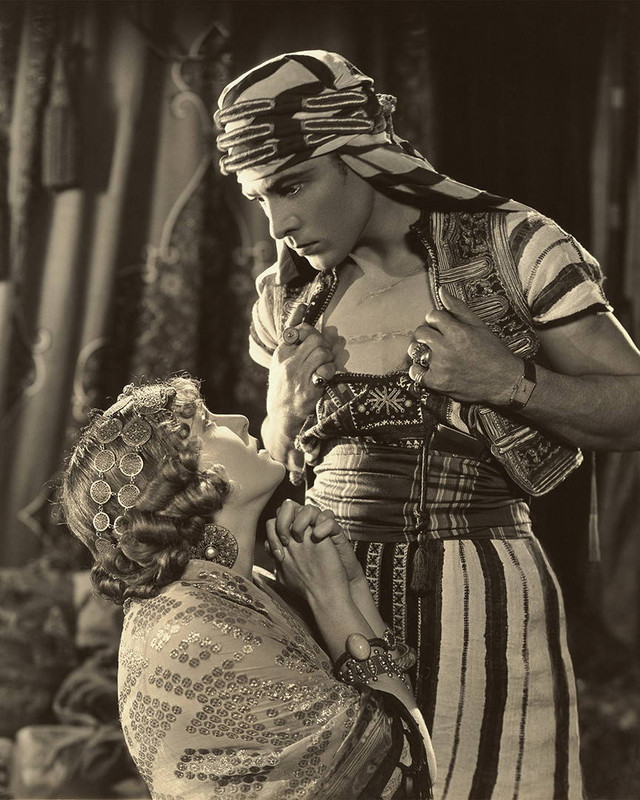Scene still of Rudolph Valentino & Vilma Banky in Son of the Sheik.\nValentino, the prototype of all matinee idols, is teamed with Blanky, the beauty known as The Hungarian Rhapsody. This would be Valentino’s last film, he collapsed at the film’s New York premiere and passed away eight short days later, a victim of peritonitis.